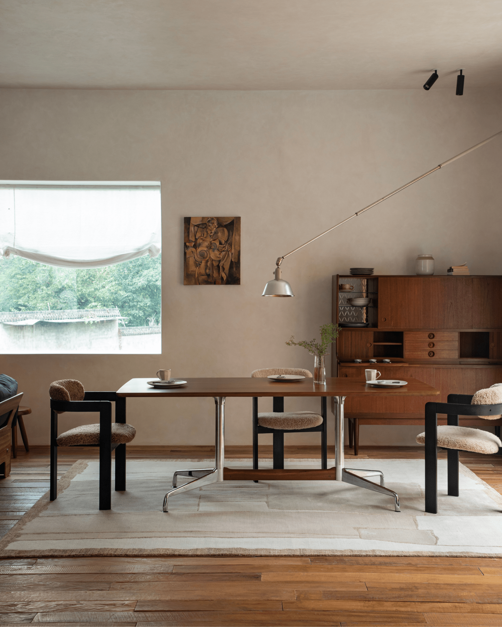 Eames Long Table in a modern dining room setting with teak veneer, stylish chairs and mid-century design