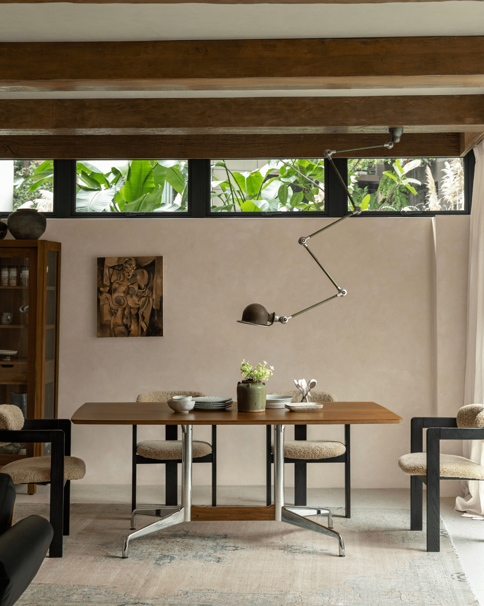Eames Long Table in modern dining room, Burmese teak veneer top, stylish chairs, mid-century modern design, sleek lamp.