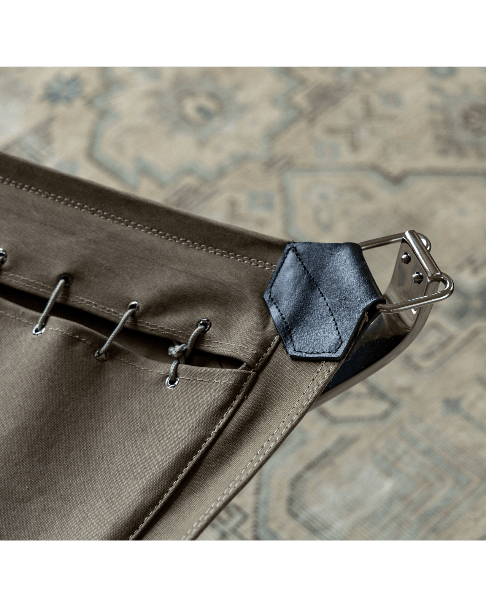 Falcon Chair detail, olive green canvas and black leather accent, stainless steel frame, Scandinavian design