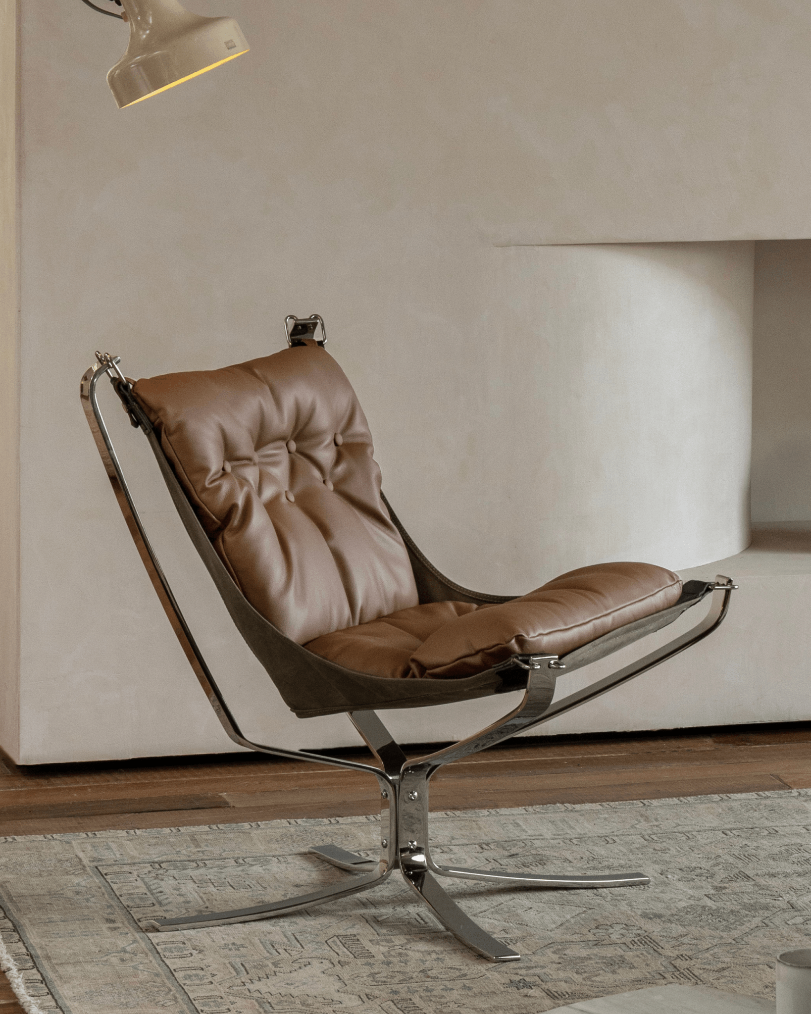 Brown leather Falcon Chair with stainless steel frame, Scandinavian design, premium comfort