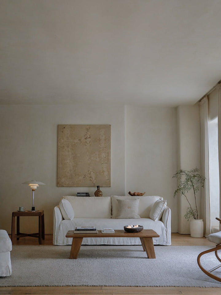 Serene living room with white sofa, wooden coffee table, and minimalist decor.