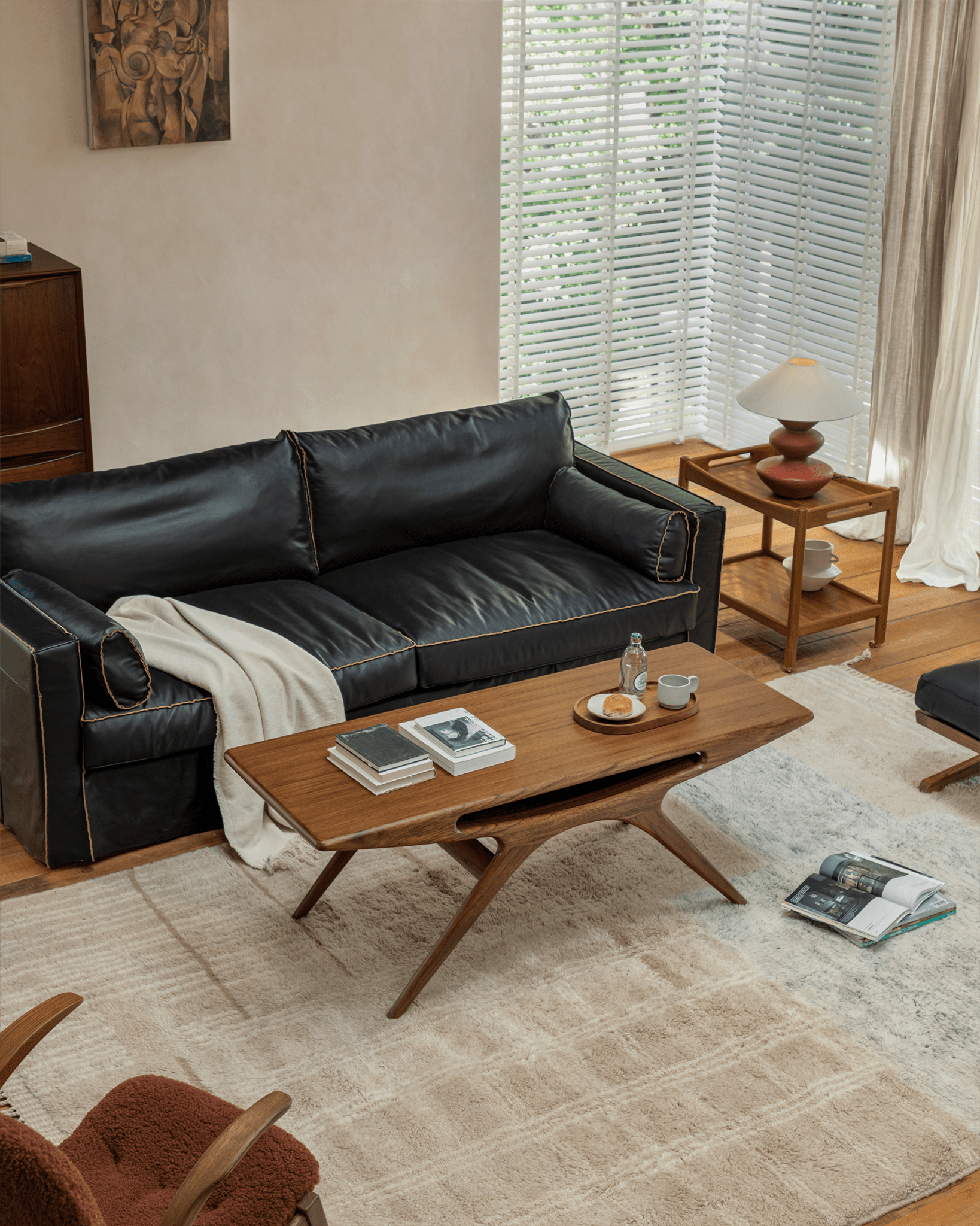 Teak Simile Coffee Table in a modern living room setting with a black leather sofa.