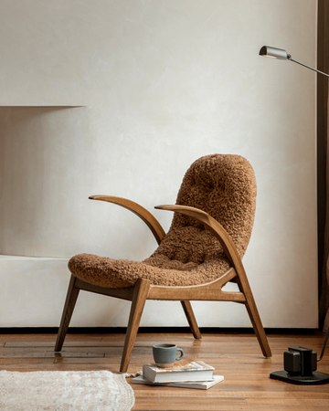 Arc shearling lounge chair with curved oak frame in warm brown