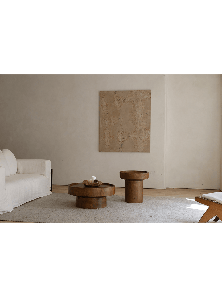 Warm wood Stamp Coffee Tables on a minimalist rug in a modern living room setting.
