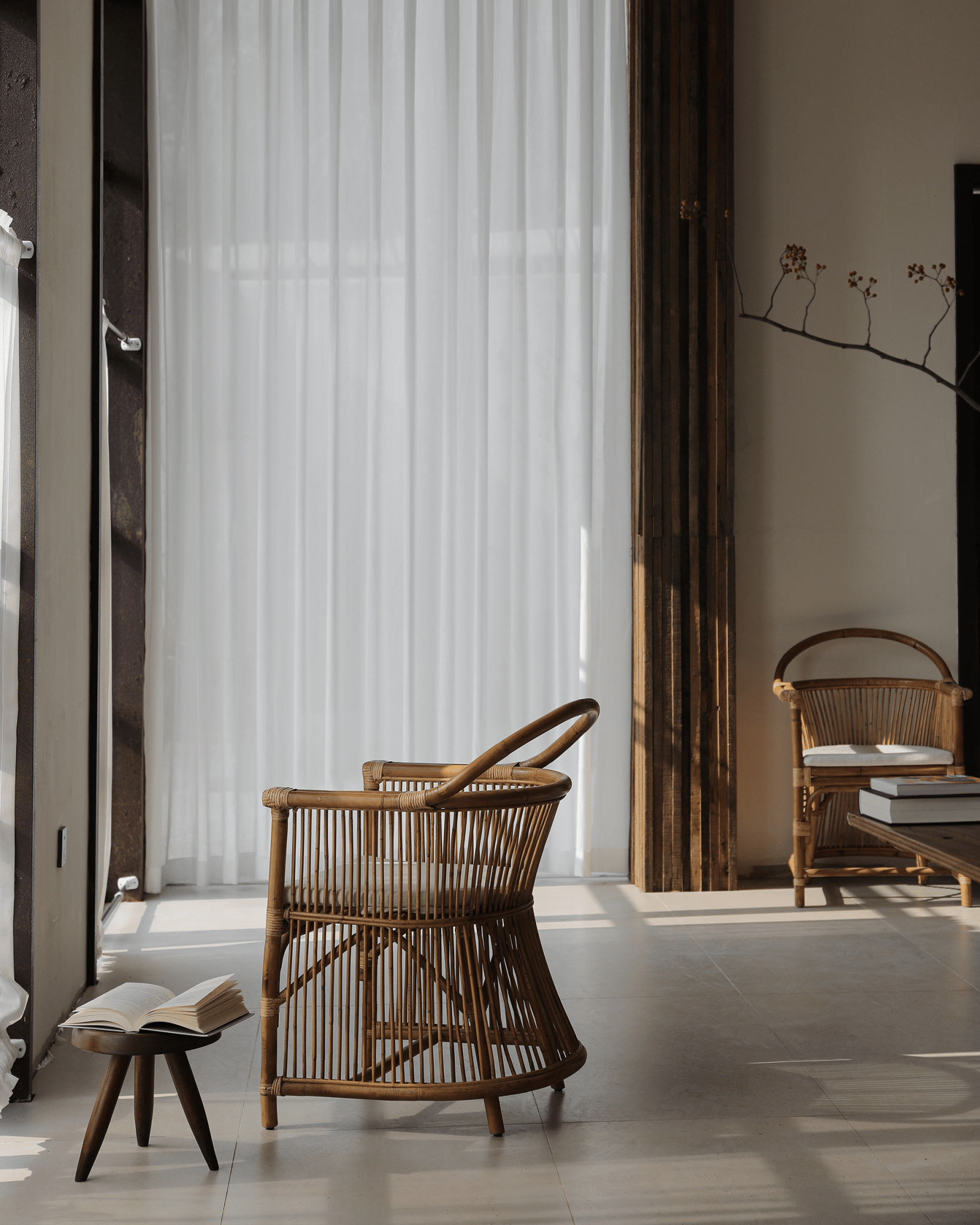 Cape Chair in rattan with hanging backrest, book and linen cushion, a stylish interior design