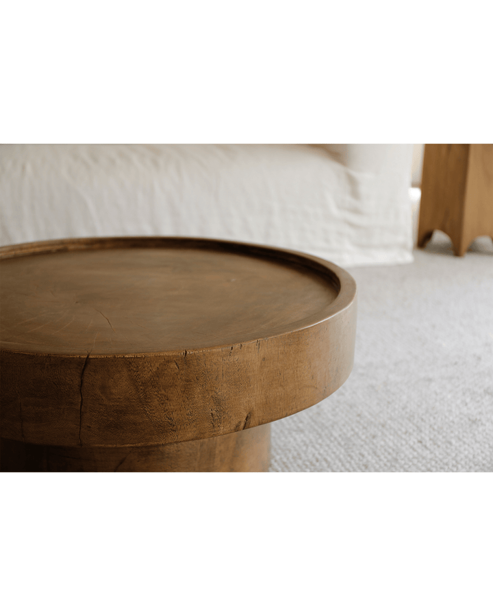 Detailed view of a warm wood Stamp Coffee Table with raised edges for functionality.