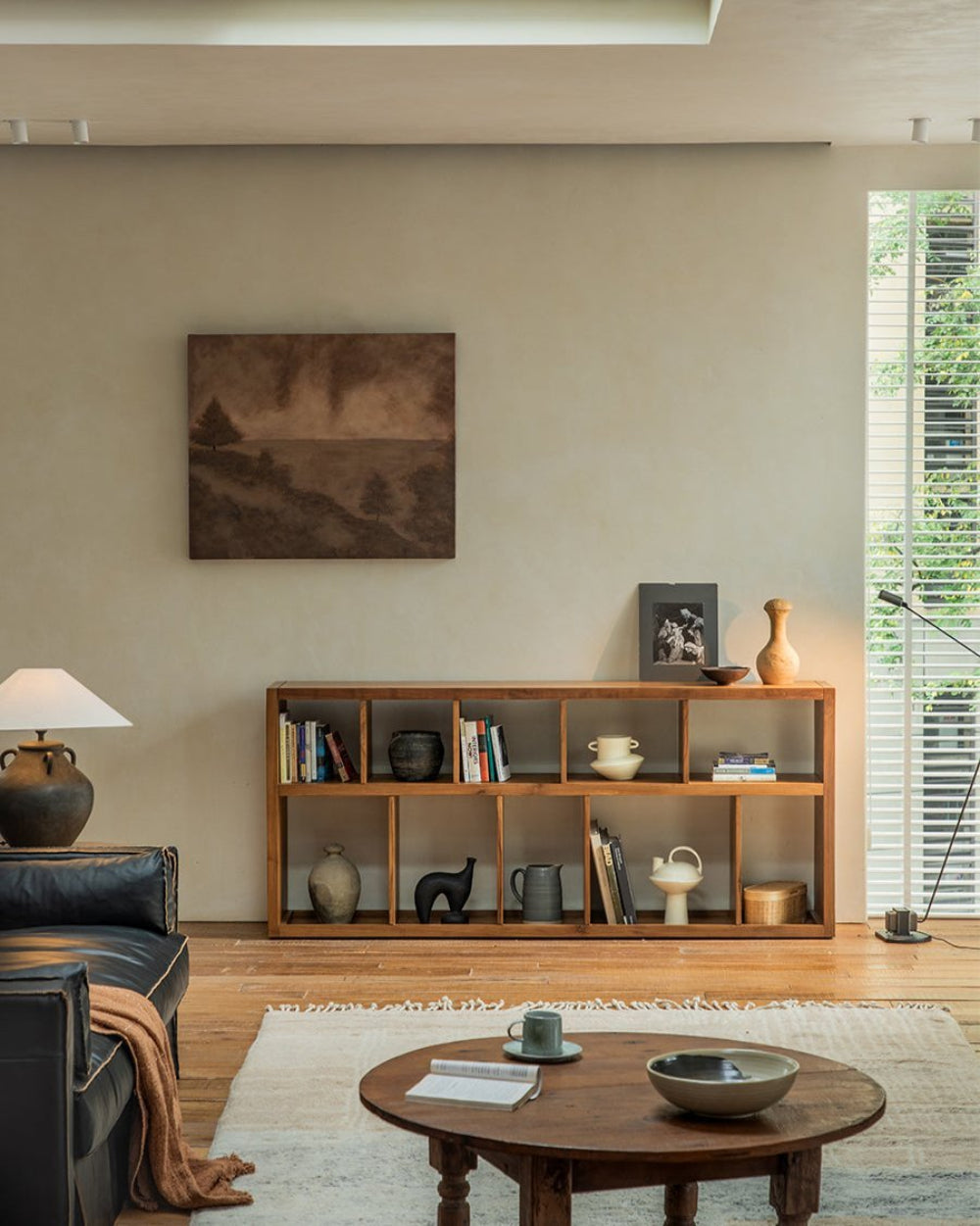 Tome Bookcase styled in a living room with decor, showing compartments for books and display items.