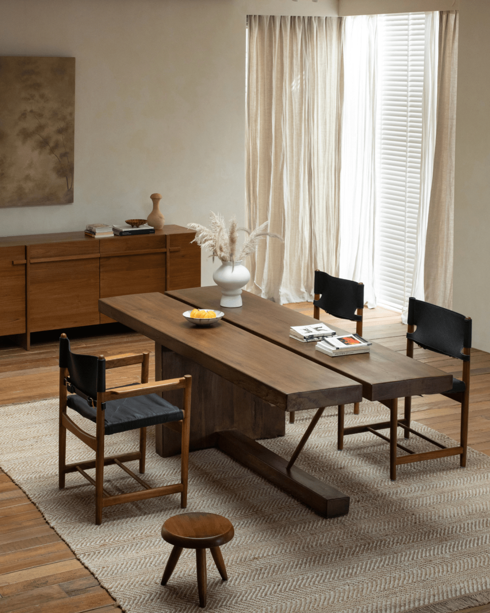 Solid wood sailboat desk in modern interior with natural light and wooden chairs