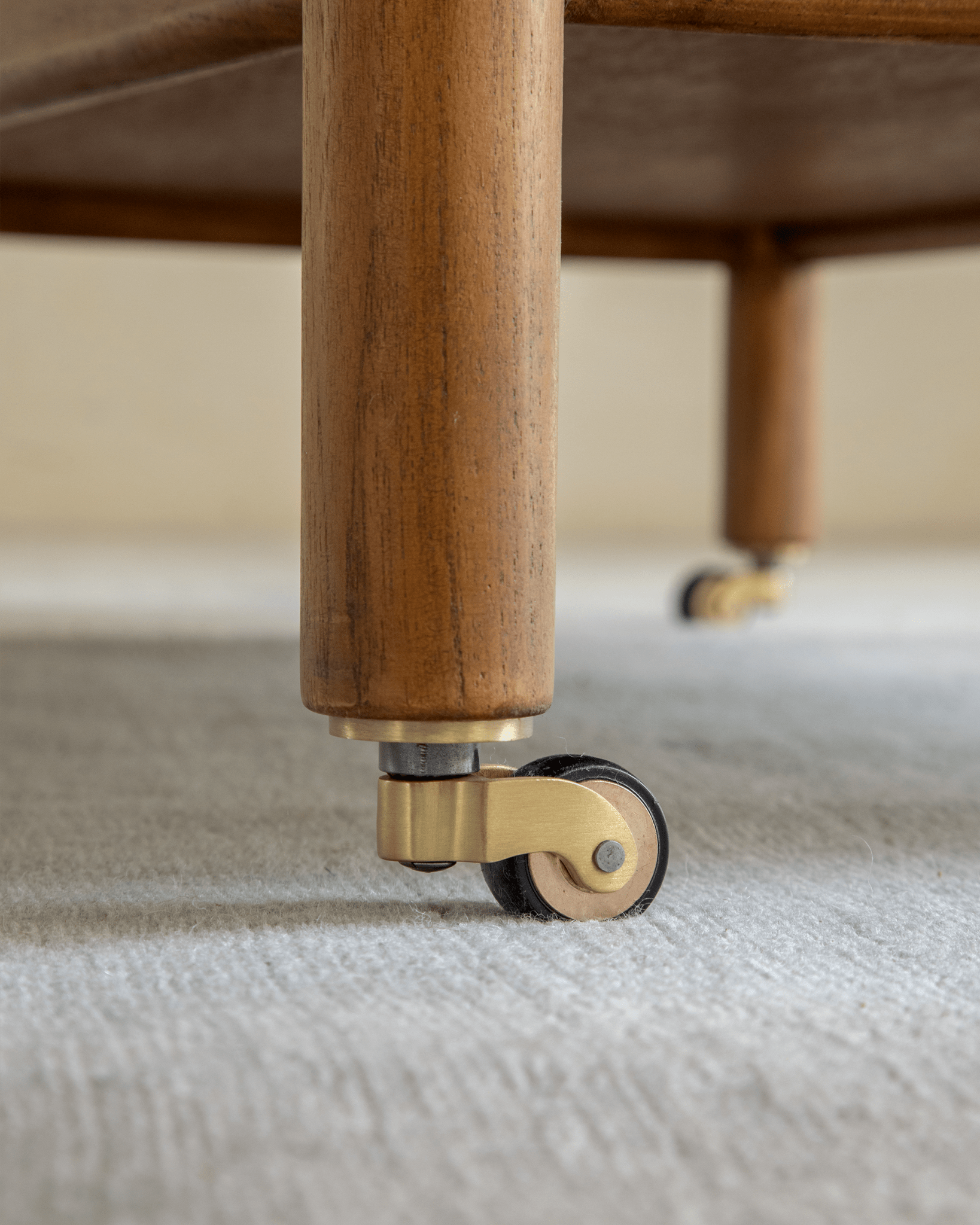 Brooklyn Bar Cart - Close-up of brass caster on a wooden leg, showing mobility and design.