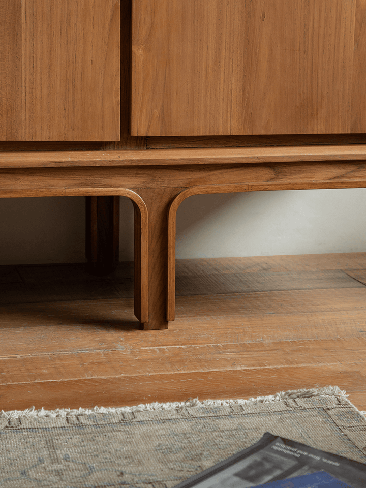 Unique leg design of NO.44 teak sideboard on wooden floor.