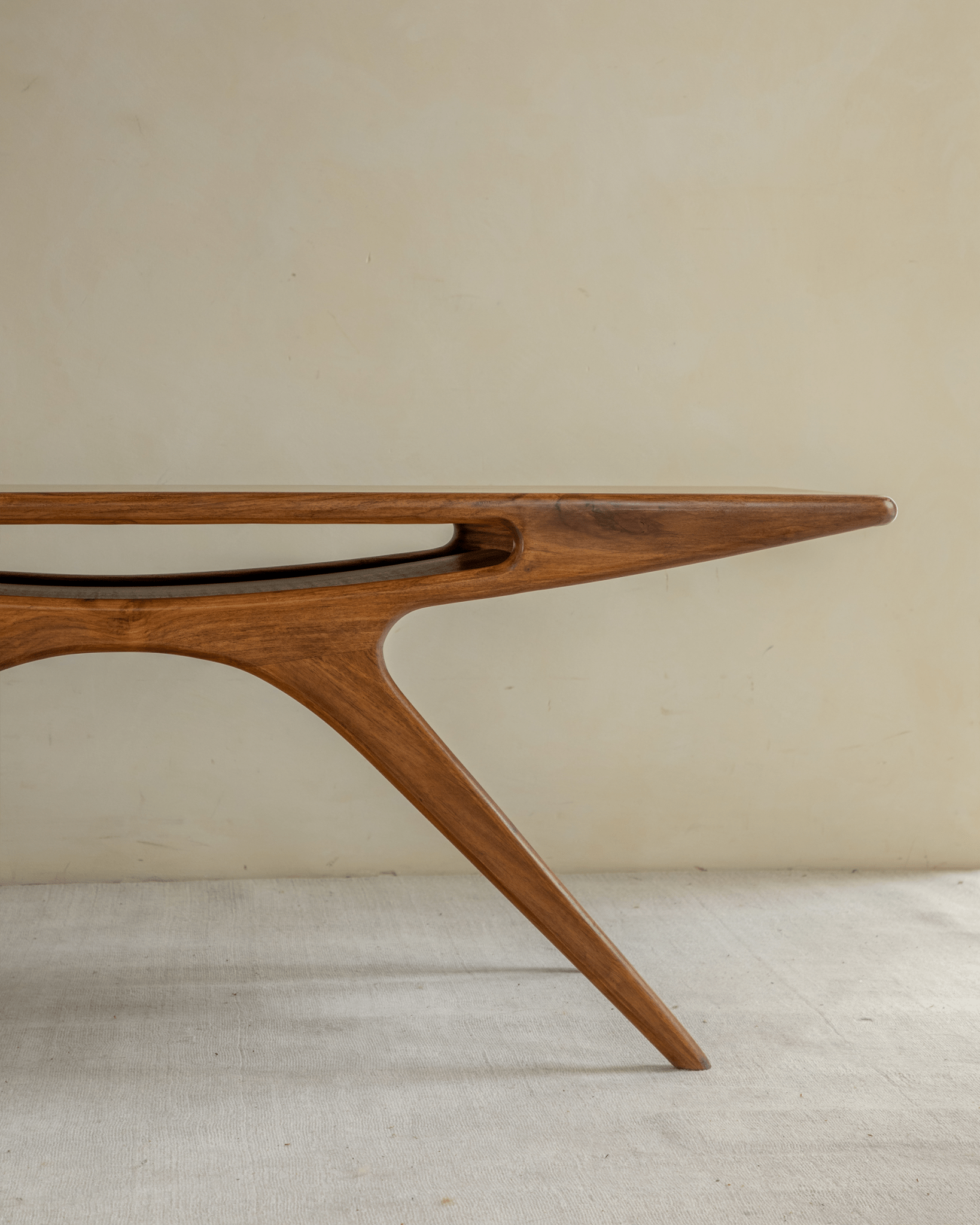 Simile Teak Coffee Table, smile cutout design, angled legs, and natural wood grain