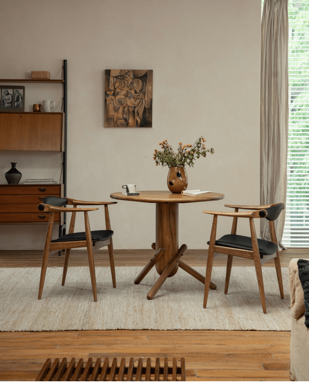CH34 Yoke Chair in ebony wood, paired with round wooden table, mid-century modern design