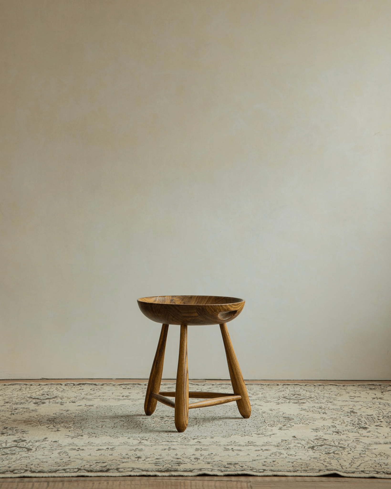 Zebrawood Mocho Stool with carved seat, natural wood grain, and tripod legs.