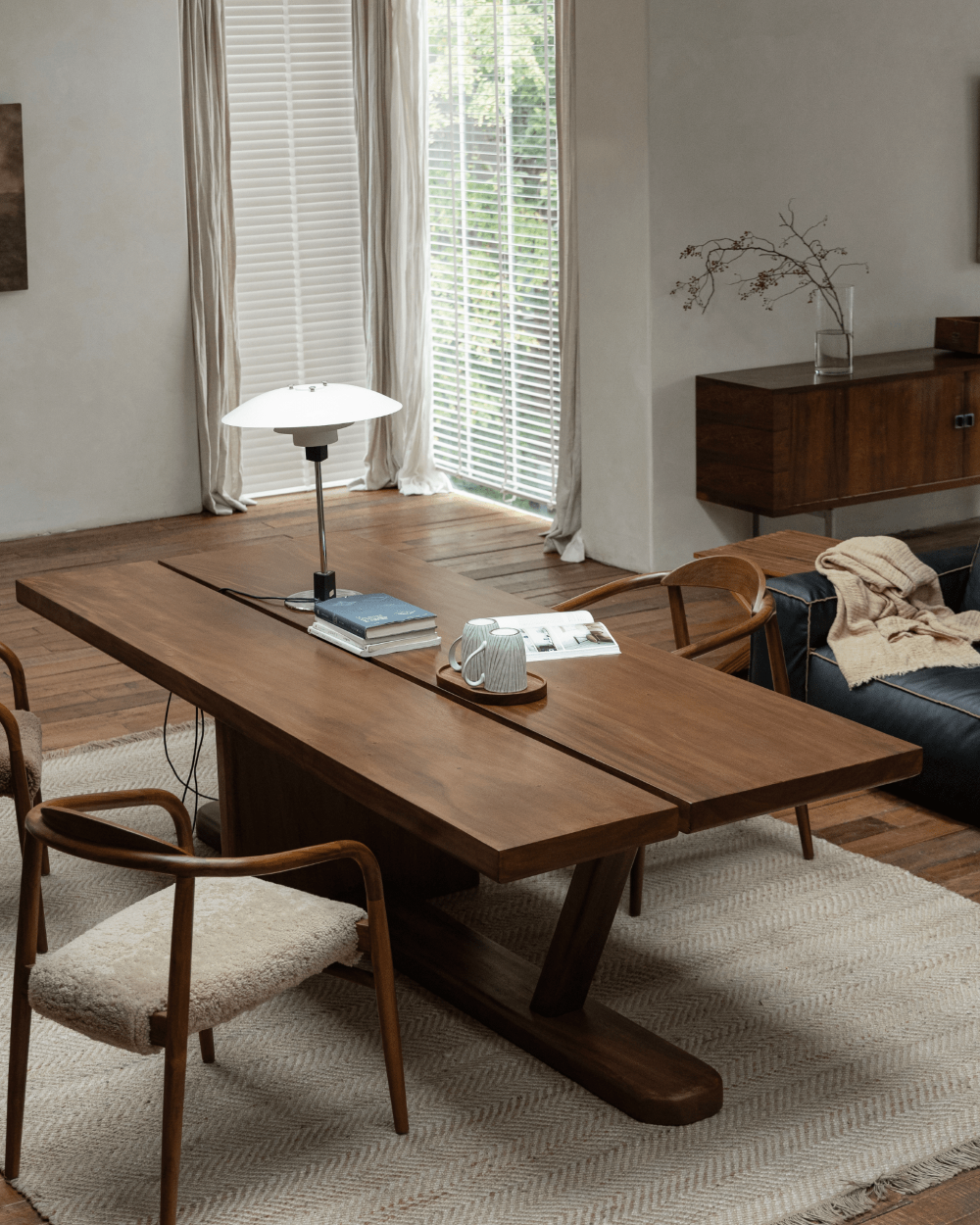Solid wood dining table with Z-shaped leg design, modern chairs and natural light