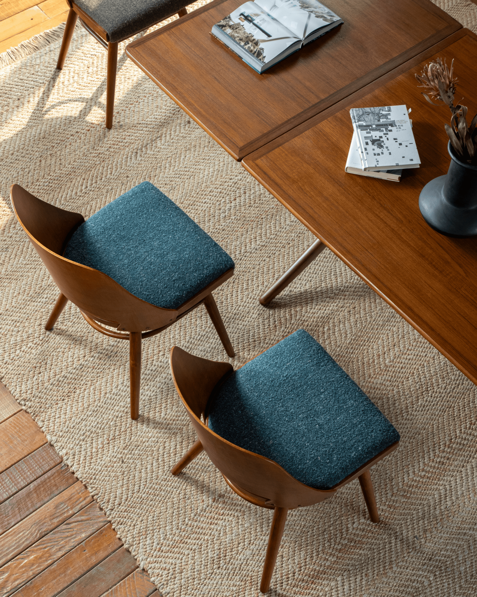 Shell Chairs with blue loop fabric seats in a mid-century modern dining scene, teak wood table