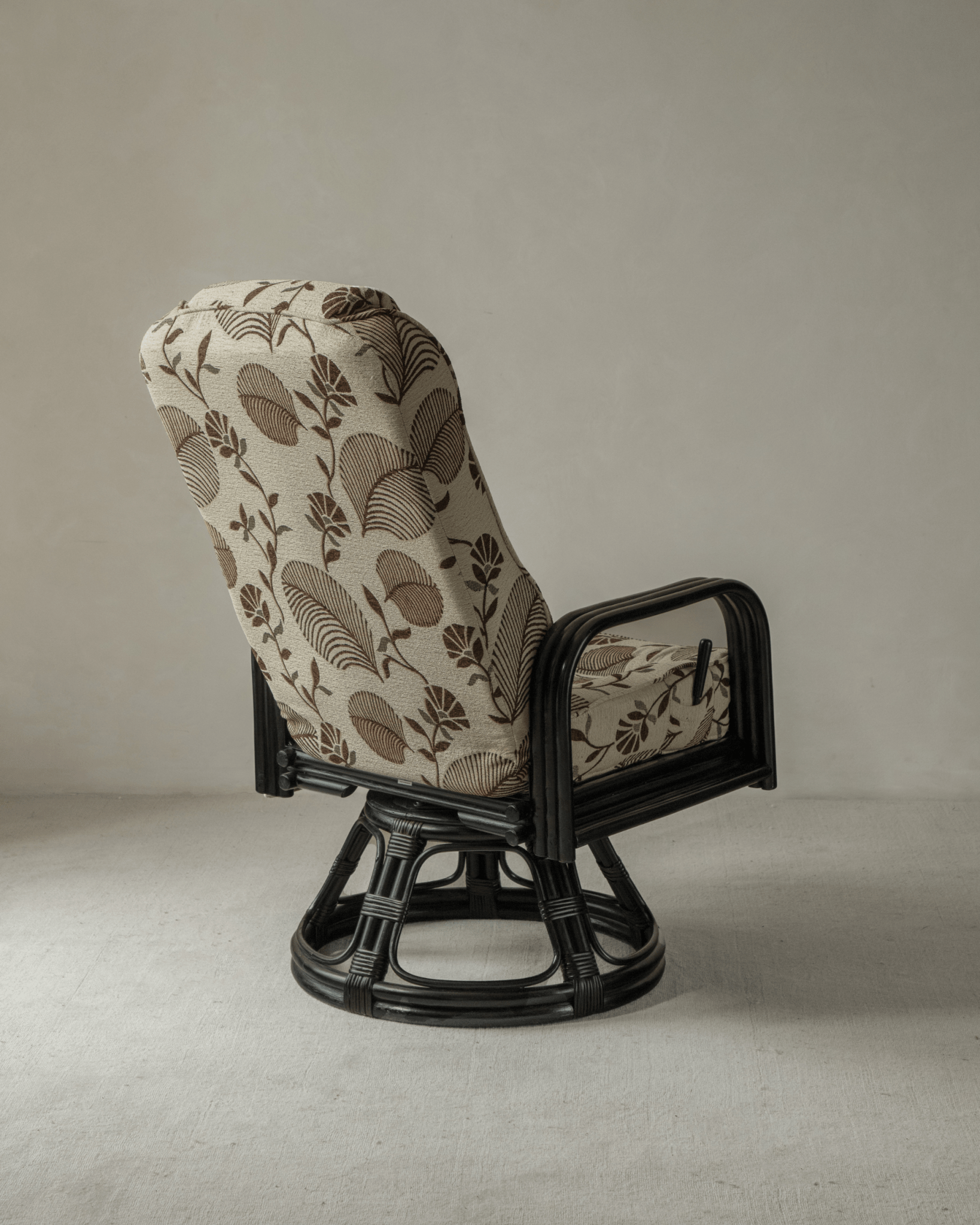 Willow rattan chair with floral leaf pattern cushion and black rattan frame