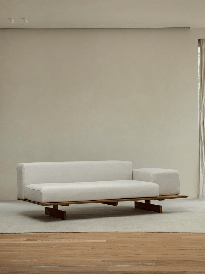 Minimalist living room with modern linen modular sofa and teak base, showcasing simplicity.