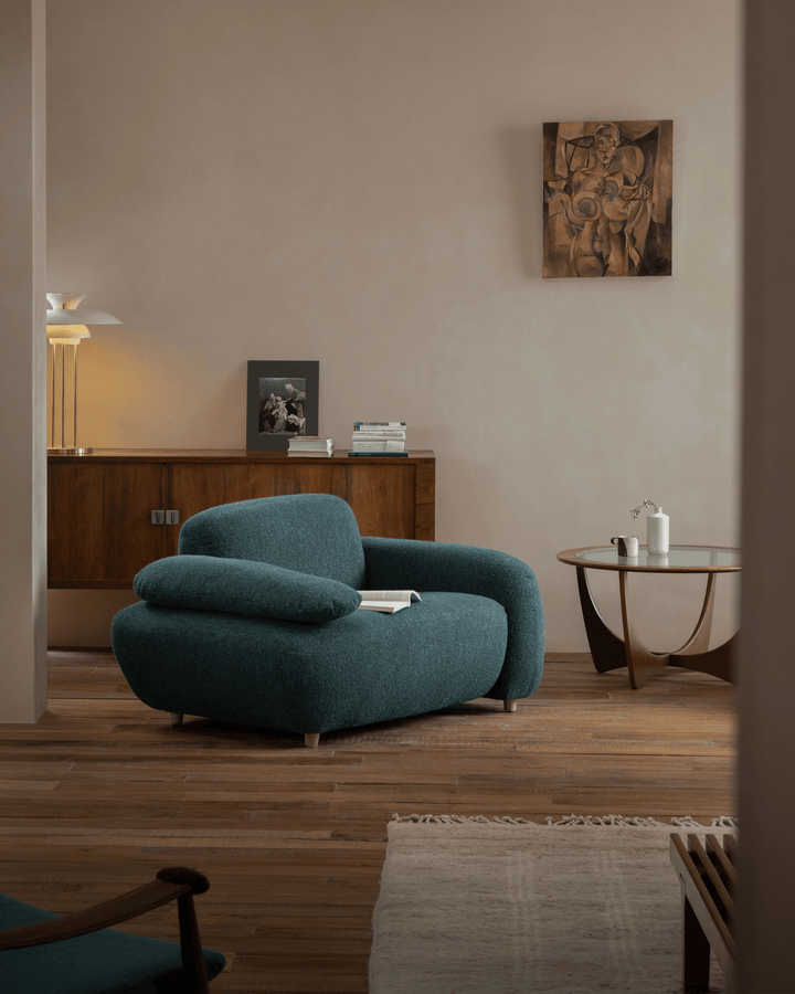 Teal Gestein Bouclé Armchair in stylish living room with wood accents and artwork
