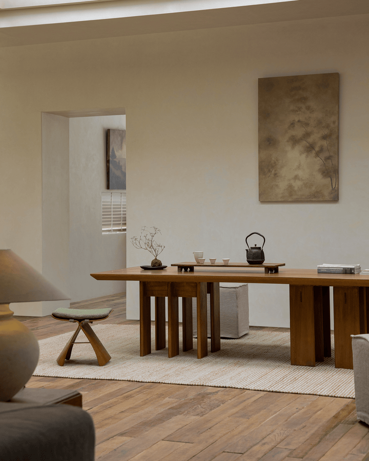Minimalist wooden dining table with tea set and natural light in a serene interior