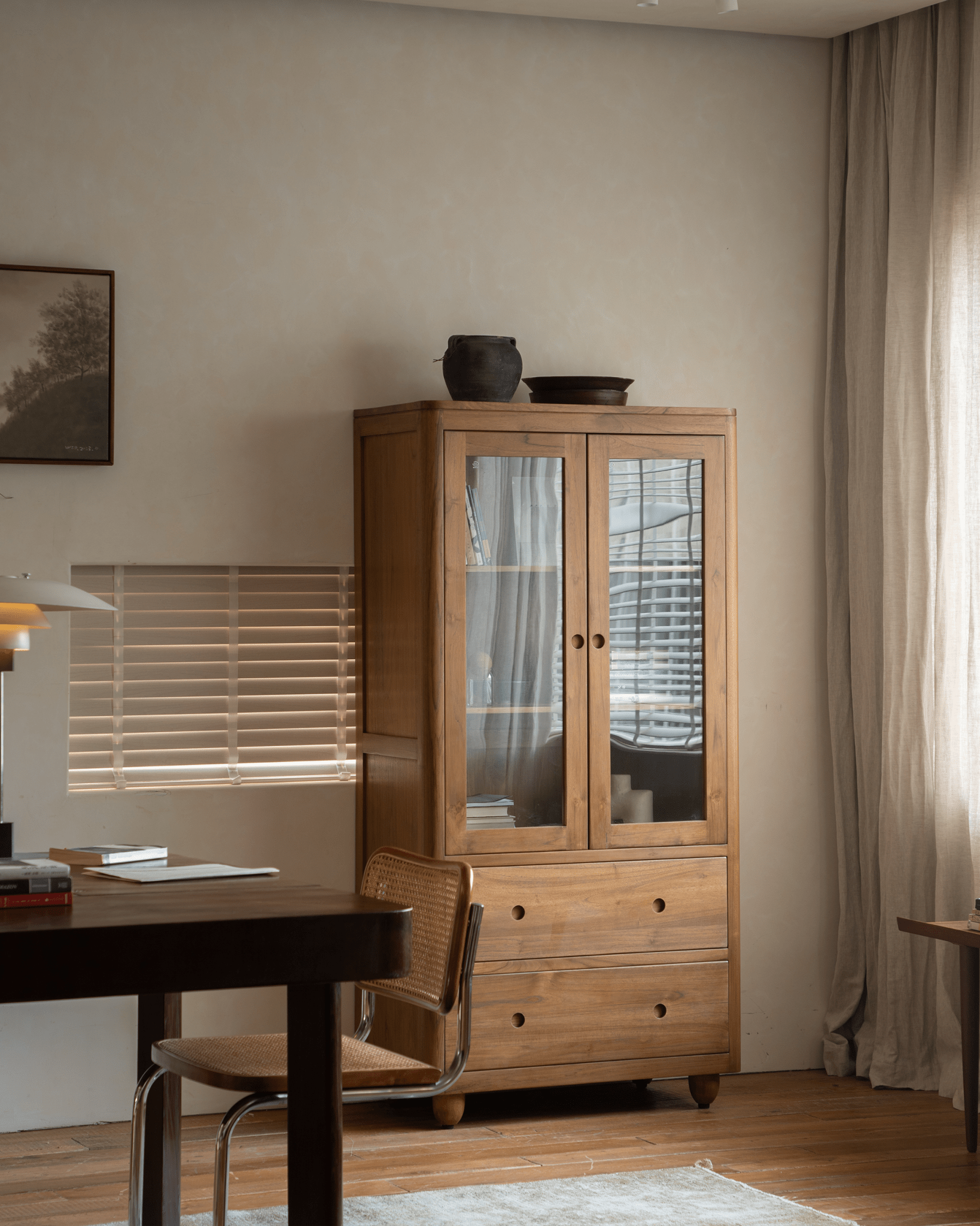 Reve Teak Bookcase in a living room setting, with double glass doors and teak wood.