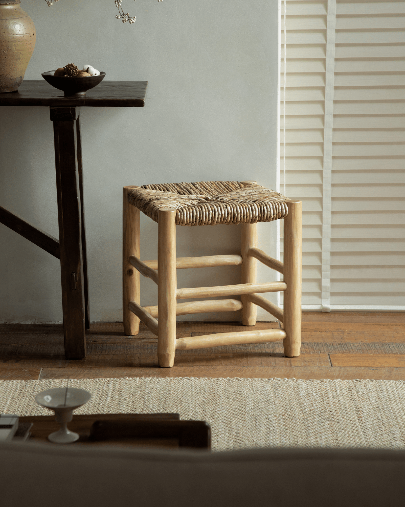 Isla Handwoven Stool: Natural wood frame with woven pandan seat. Modern organic design.