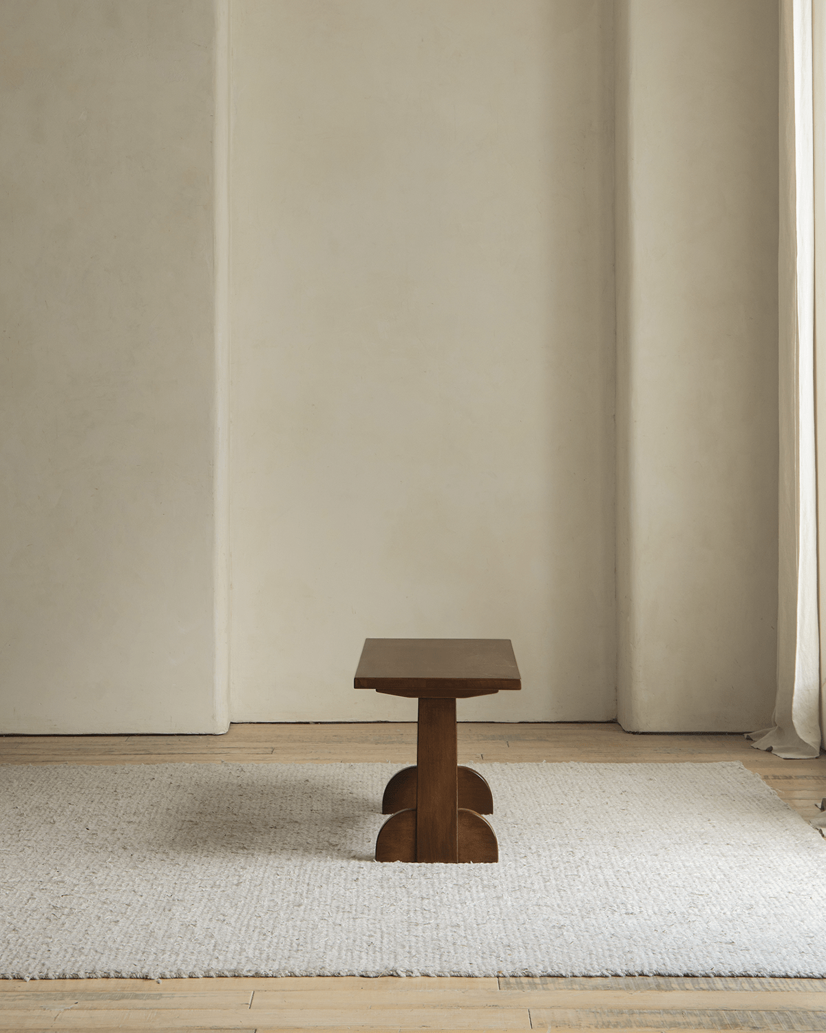 Hoof Side Table in nanmu wood on a neutral rug, showcasing horseshoe legs and retro design.