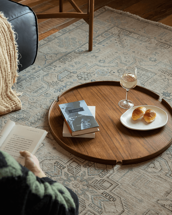 Hansen Tray Side Table with books, wine glass, and croissants in cozy living room.