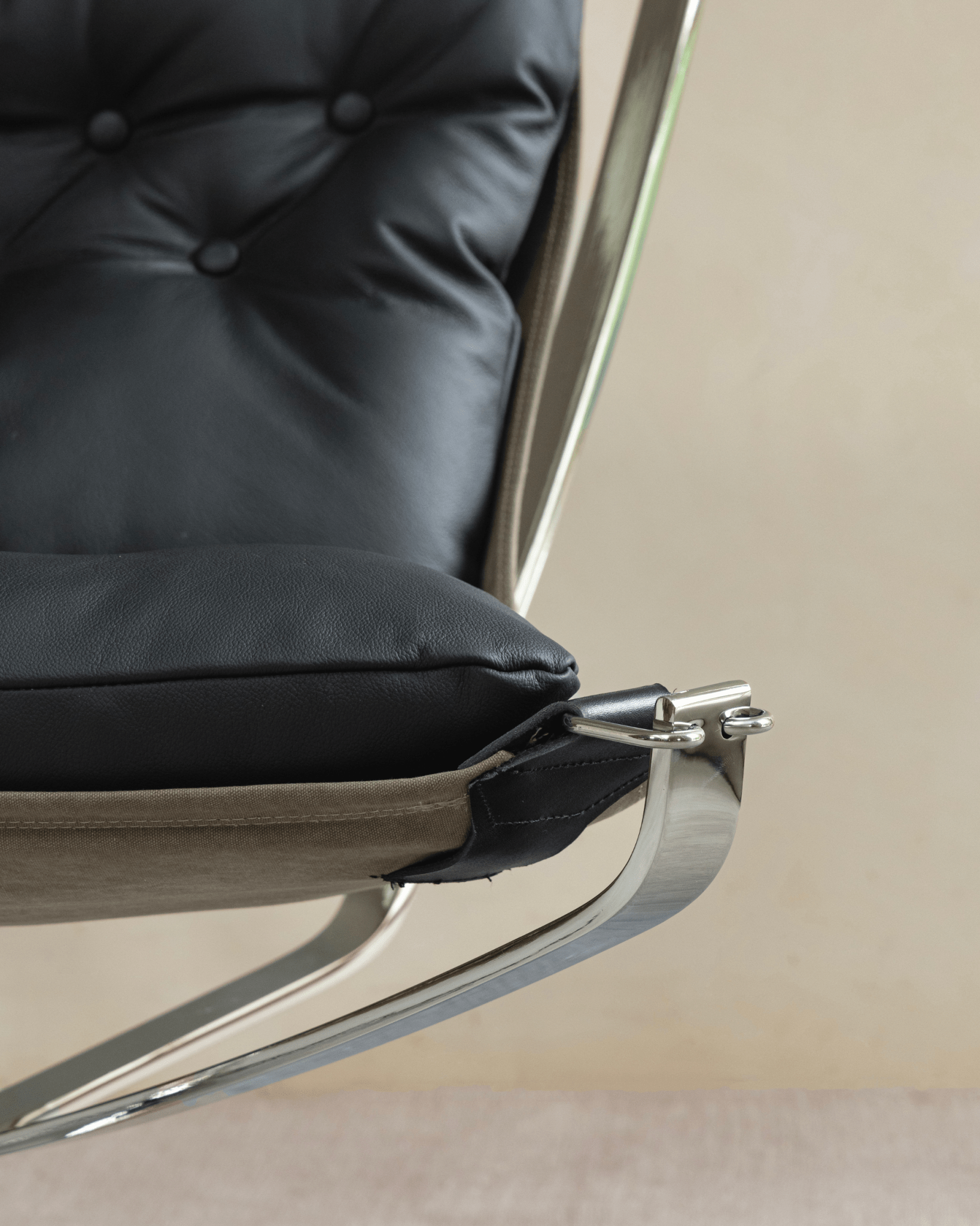 Falcon Chair detail: Black leather cushion and stainless steel frame, Scandinavian design