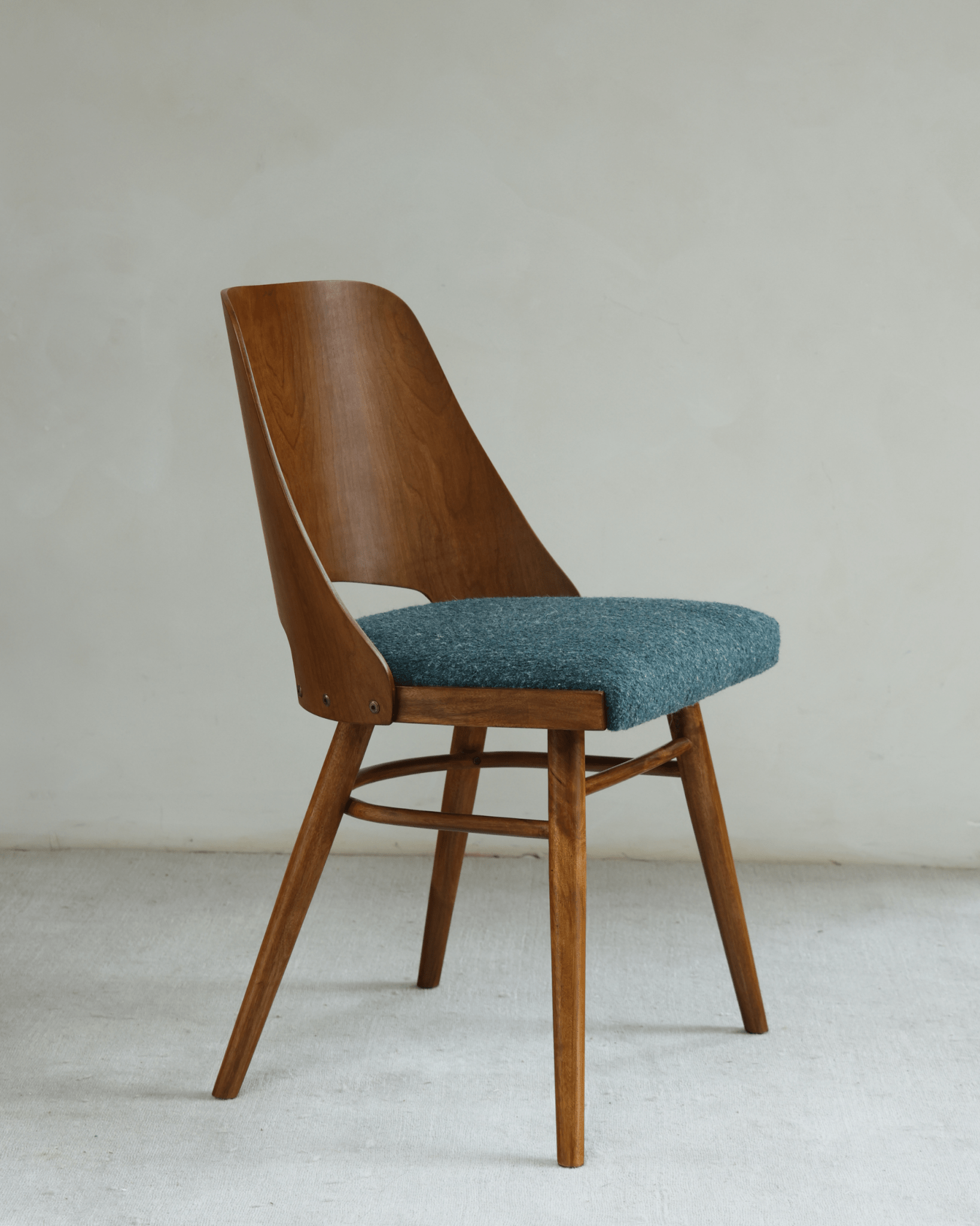 Shell Chair - Teak wood chair with blue loop fabric seat, mid-century modern design.