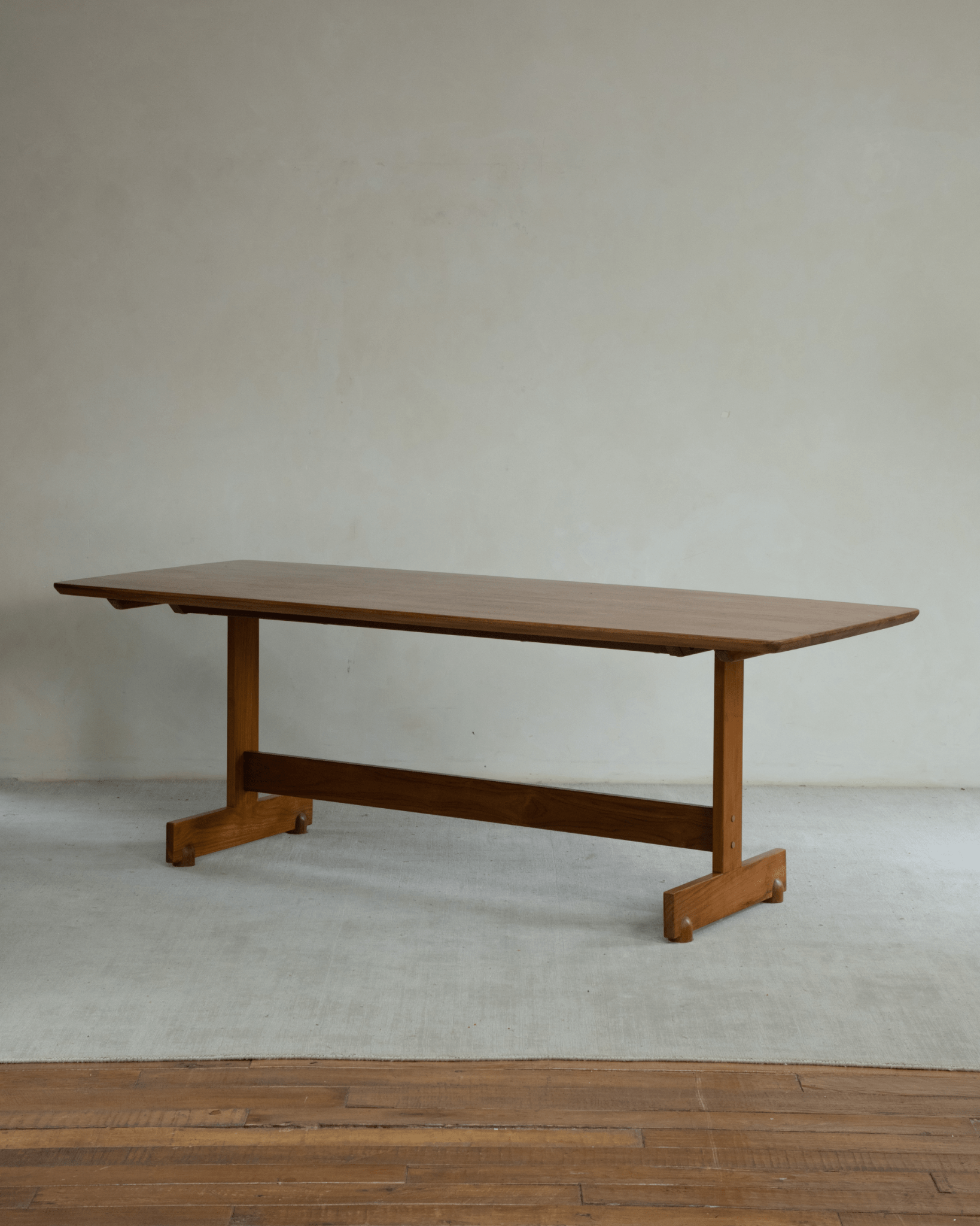Hoof Dining Table, solid wood with I-shaped base and warm brown finish, ideal for dining or working.