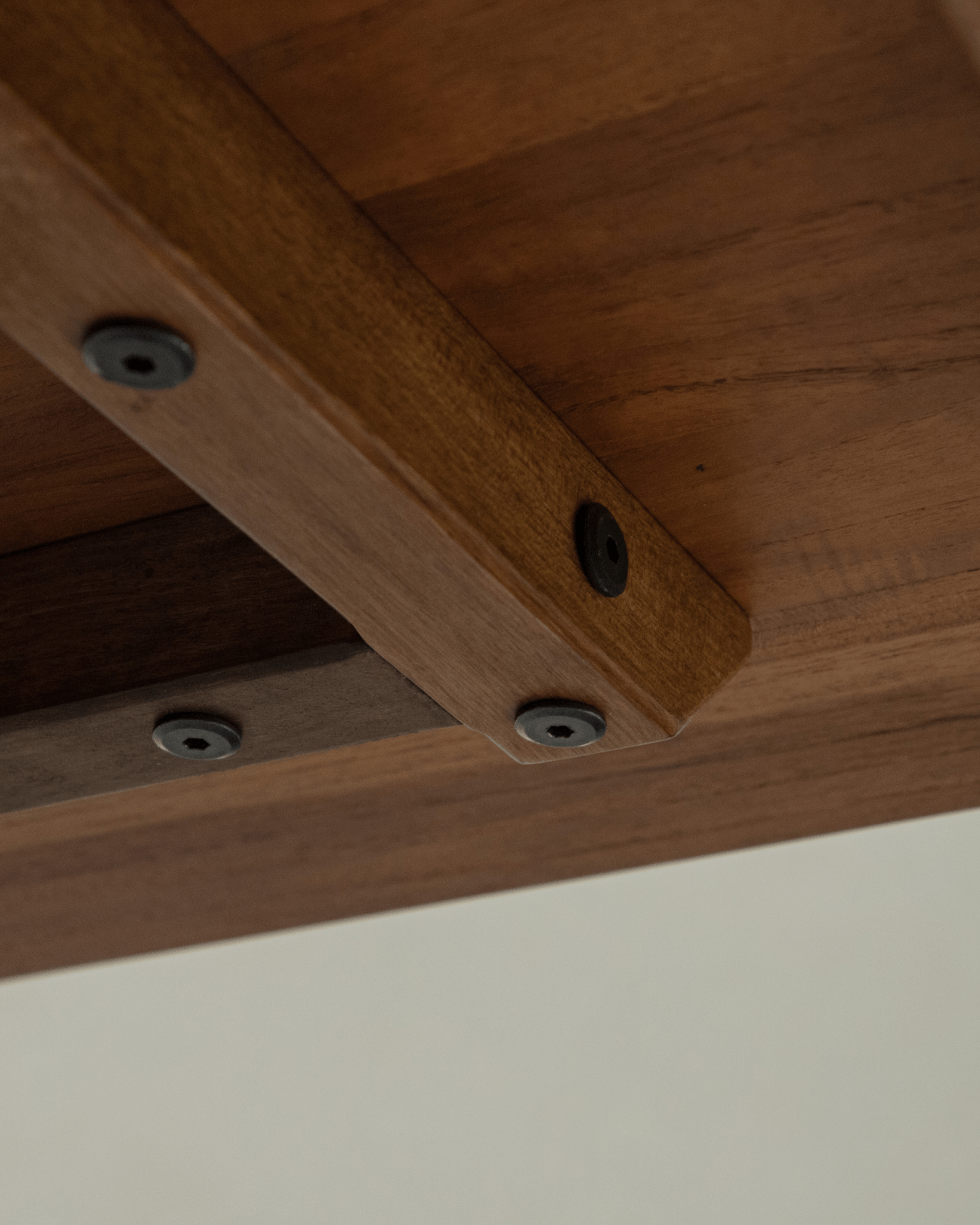 Hoof Dining Table detail: solid wood table top with reinforced support and black hardware, I-shaped base.