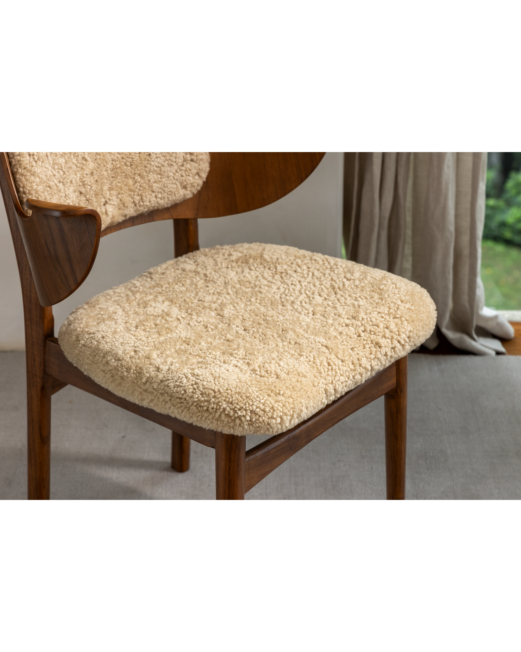 Maren Chair: beige lambswool upholstery, curved teak wood frame and armrest.