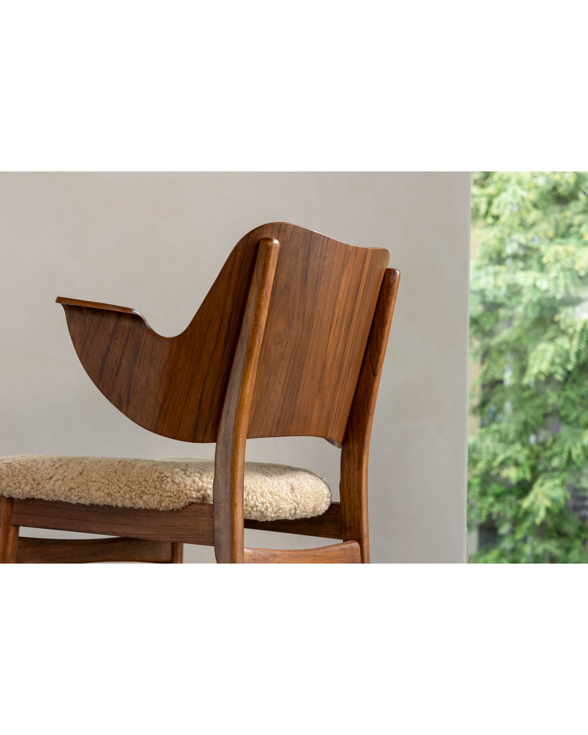 Maren Chair: Curved teak wood frame and soft lambswool seat.