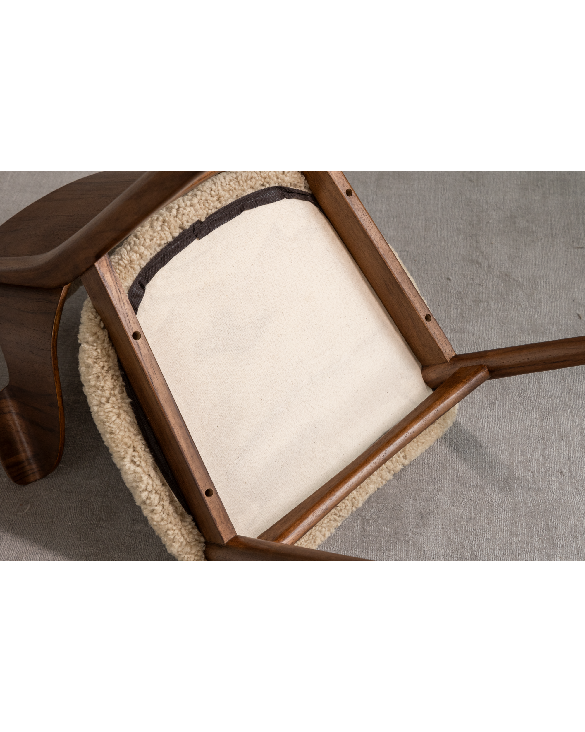 Maren Chair underside view with dark wood frame and lambswool upholstery.