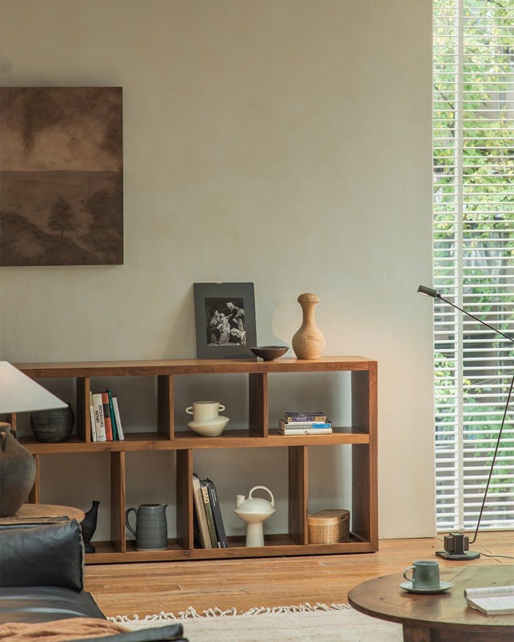 Tome Bookcase styled in a living room, solid wood with multiple compartments, showcasing books, decor and a cozy interior.