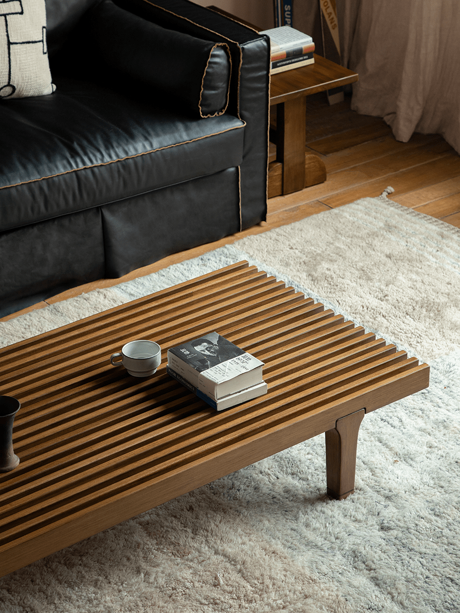 ZM Daybed Coffee Table in teak wood, minimalist design, with slatted top, books and a cup.