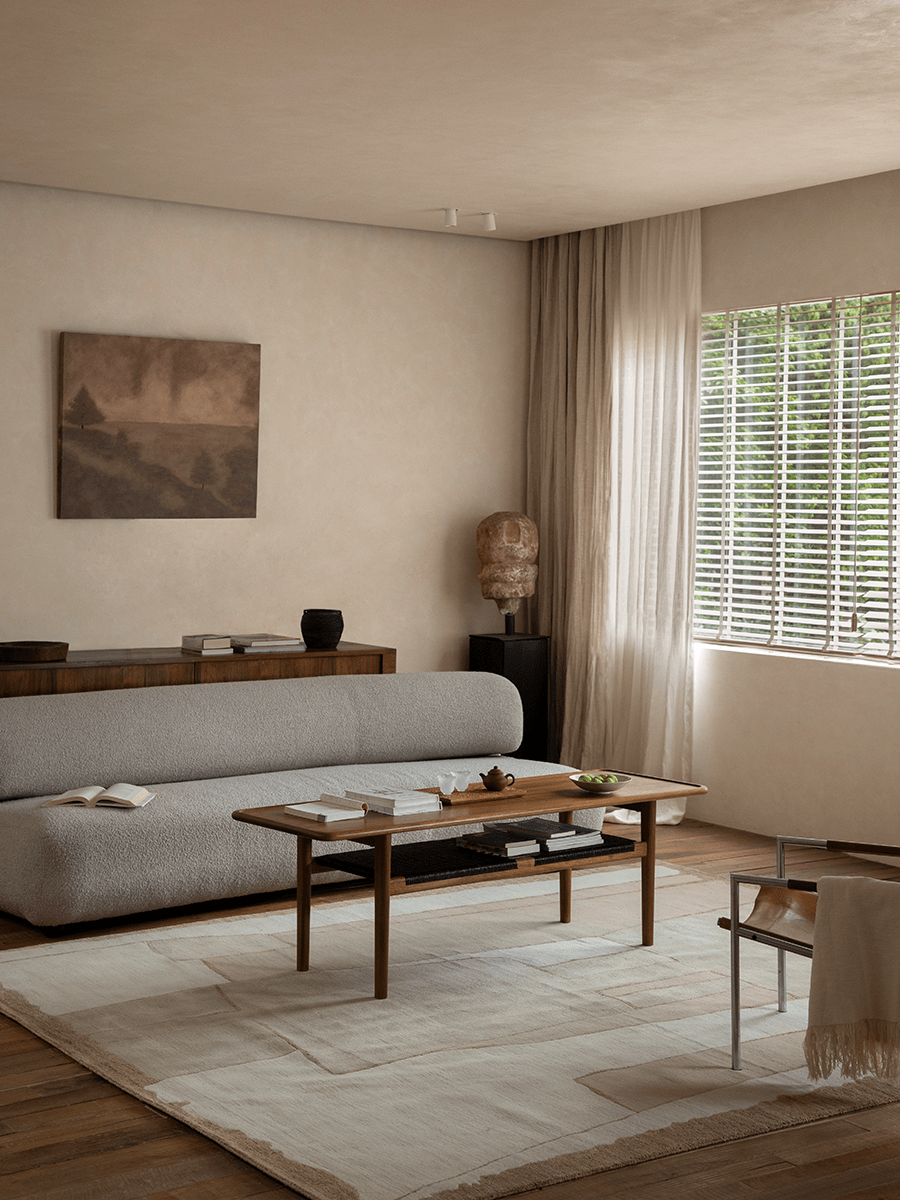 Hans Accent Table in a minimalist living room setting, wooden coffee table with woven shelf, modern decor.