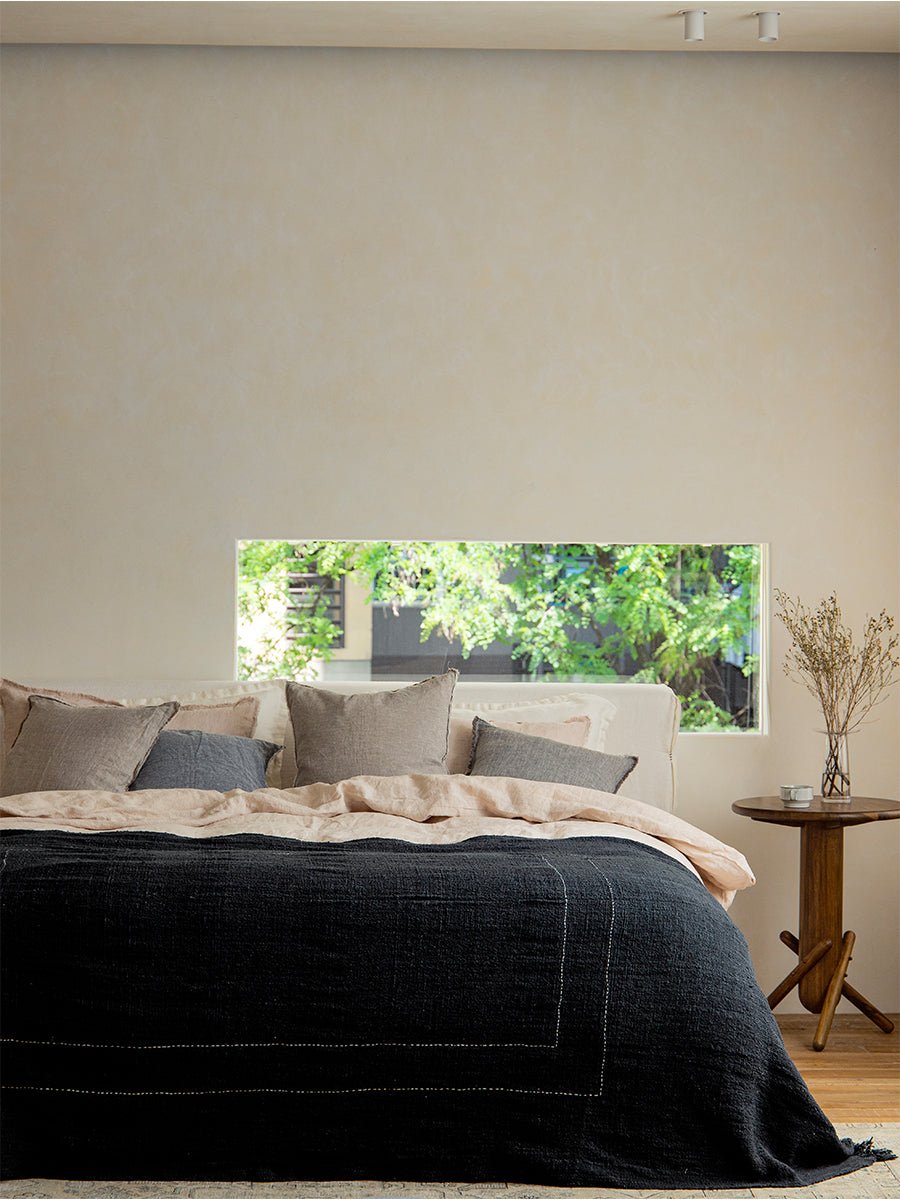 Dark gray cotton blanket on bed, cotton with white stitch detail, perfect for home decor