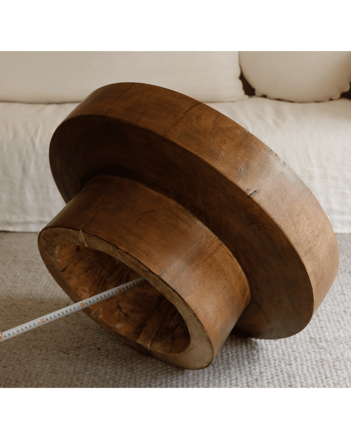 Close-up of warm wood Stamp Coffee Table with raised edges and measuring tape for size.