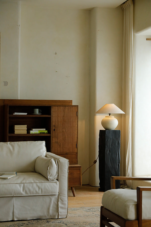 Clay moon lamp with beige lampshade, dark base stand, and white sofa, perfect for bedside or living room lighting