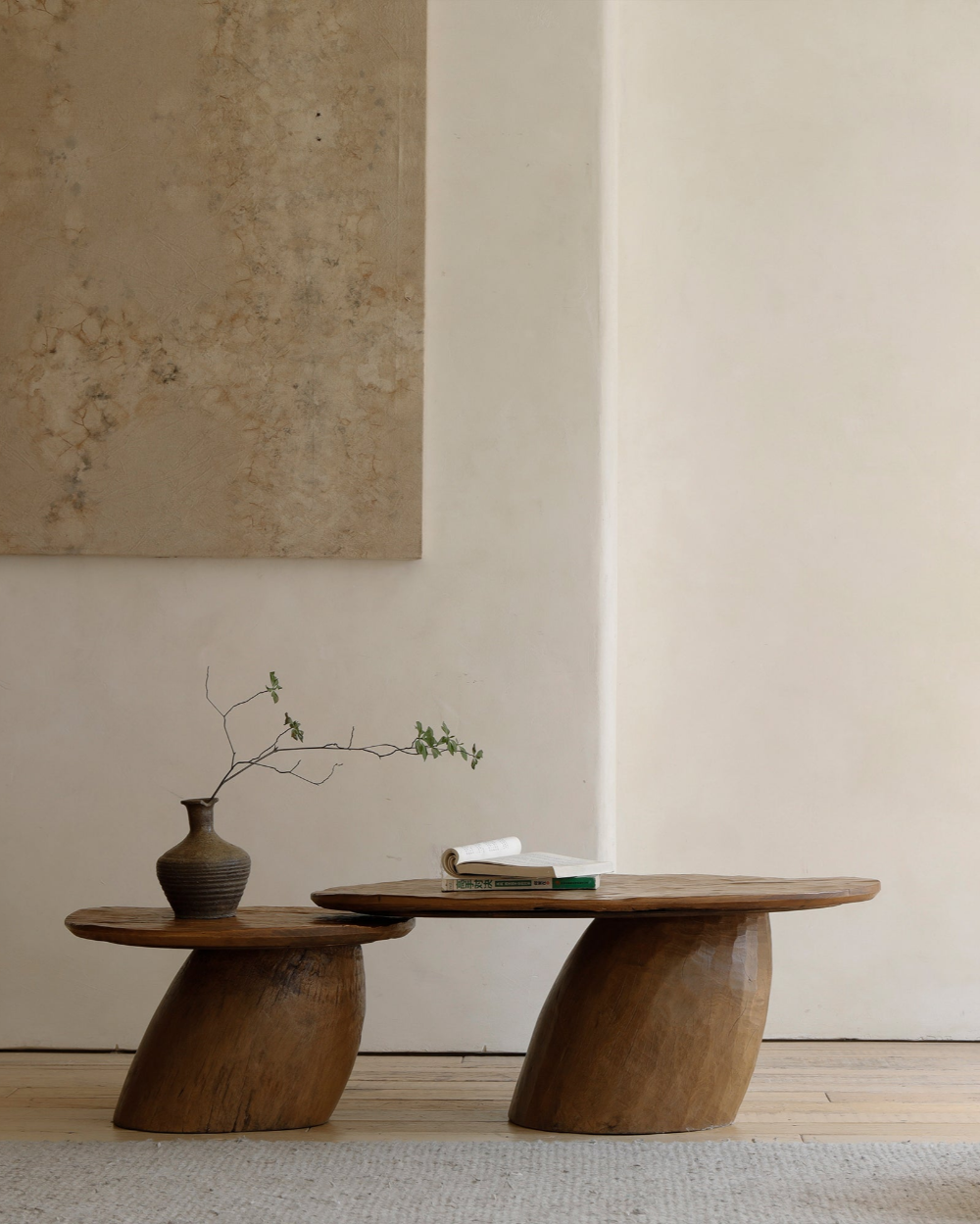 Alva Side Table in natural wood. Playful, organic design with a vase and a book.