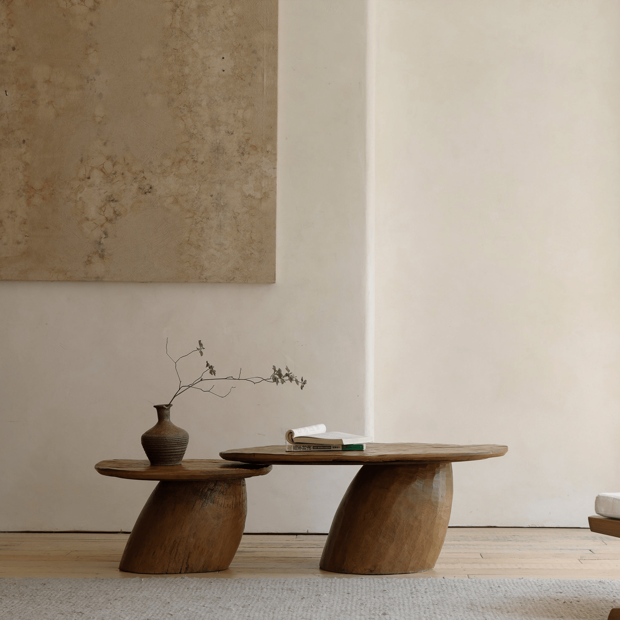 Alva Side Table in natural wood. Playful, organic design with a vase and a book.