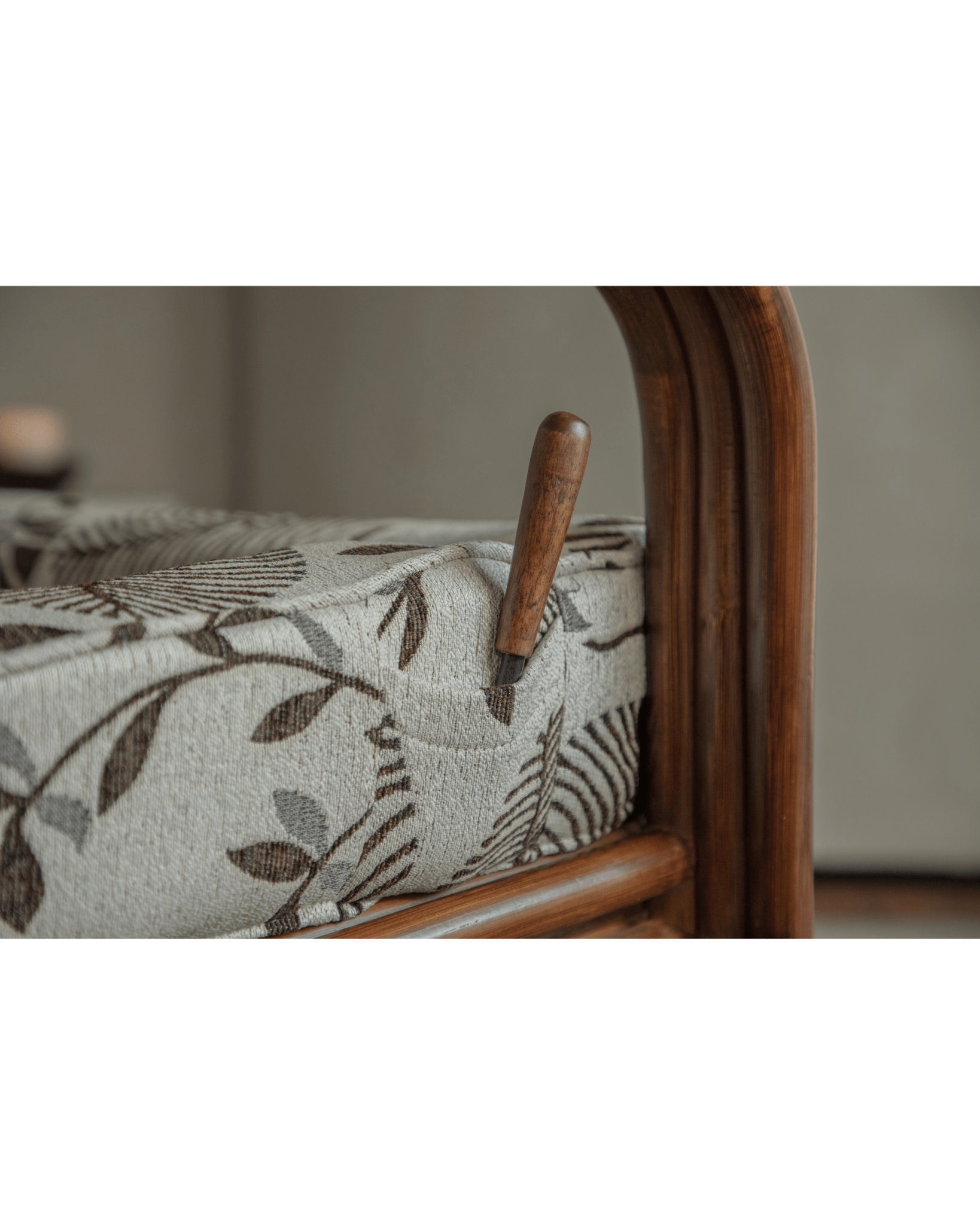 Close-up detail of Willow rattan chair floral leaf cushion, armrest, and Indonesian rattan frame