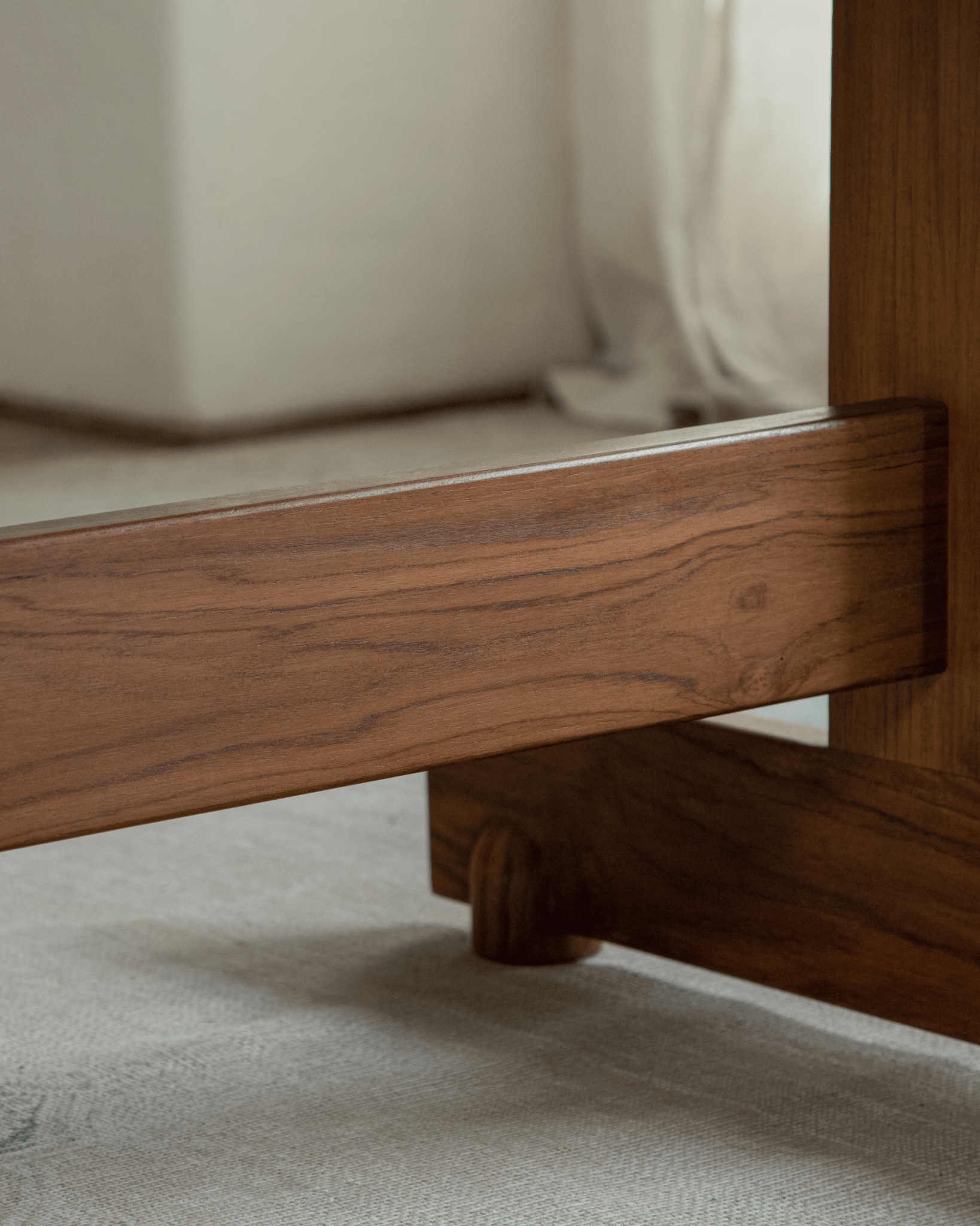 Hoof Dining Table detail, solid wood I-shaped base in warm brown finish, highlighting design and stability