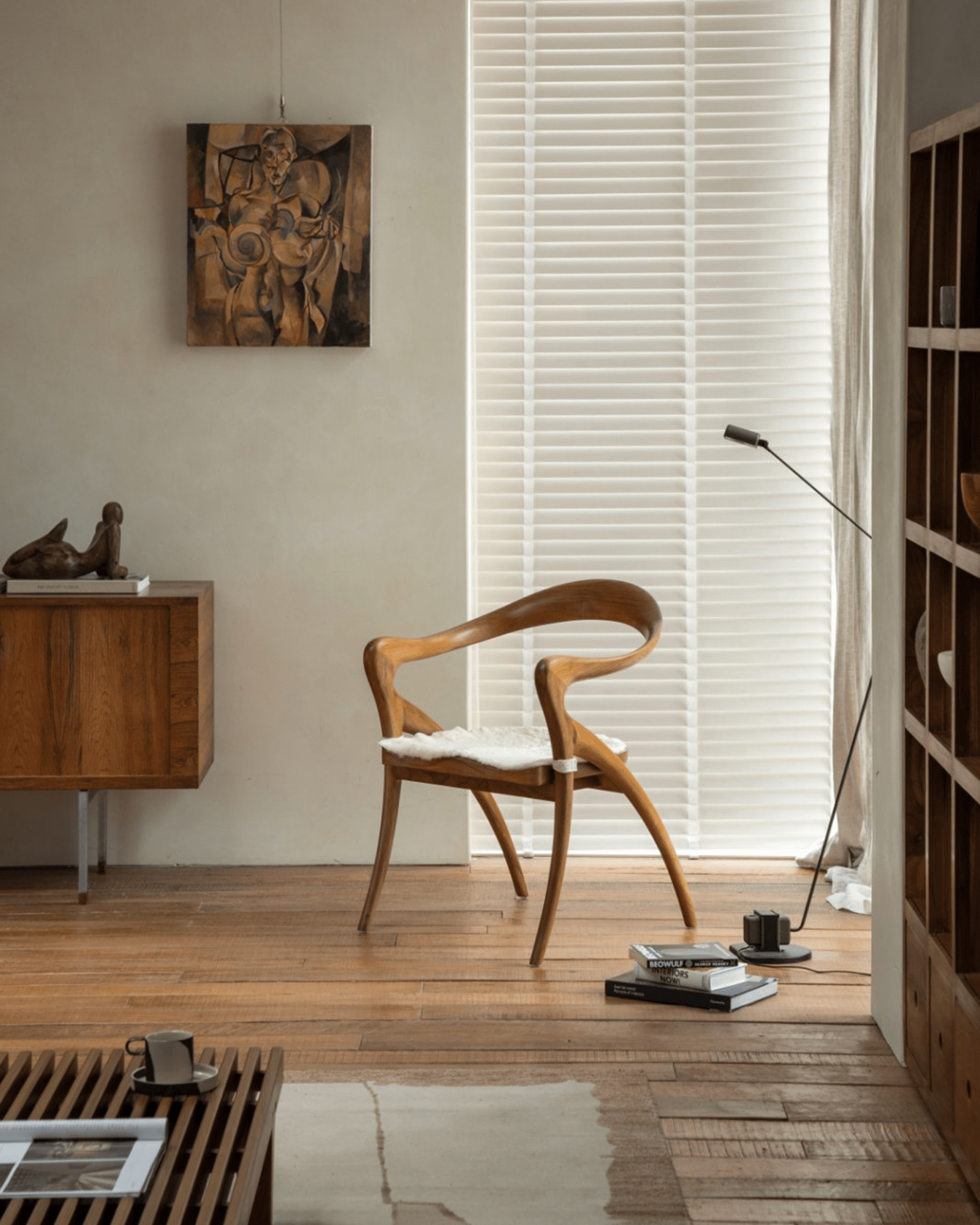 Olivia Chair in a modern interior setting. Solid teak wood, curved back, fur cushion, modern design.