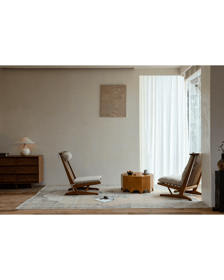 Stylish living room with Decagon Side Table and two wooden chairs bathed in natural light.