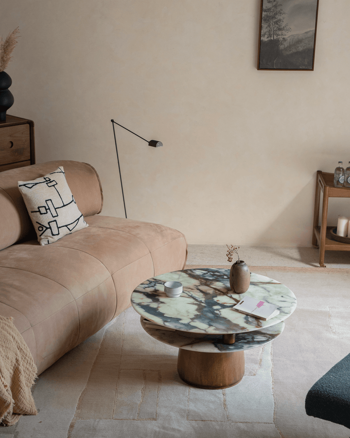 Round crystal stone side table with wooden base in a cozy living room setting.