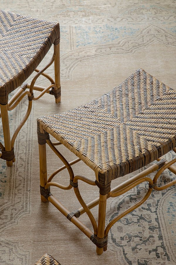 Two handcrafted Melange Stools in Manau rattan on a decorative rug