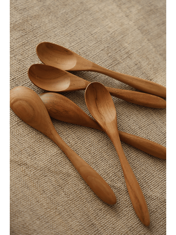 Handcrafted wooden serving spoons displayed on burlap fabric