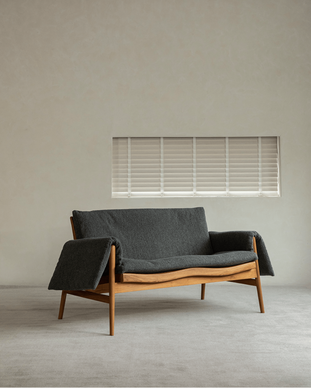 Modern teak wood garden lounge chair with dark grey cushion and blanket, indoor comfort, stylish design